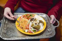 Persona che detiene falafel con diversi accompagnamenti — Foto stock
