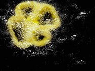 Шматочок перцю в гарячій олії на чорному тлі — стокове фото