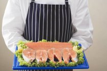 Various cuts of salmon on chopping board — Stock Photo