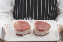 Chef segurando carne embalada em bacon — Fotografia de Stock