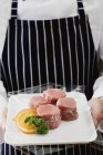 Шеф-кухар тримає лоток зі свинячих медальйонів — стокове фото