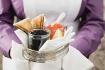Vue recadrée de la femme de chambre servant du caviar et des toasts — Photo de stock