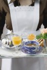 Обрізаний вид на служницю, що подає сніданок з кавою та соком — стокове фото