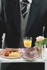 Butler que serve pequeno-almoço inglês na bandeja — Fotografia de Stock