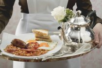 Cameriera che serve colazione inglese su vassoio — Foto stock