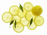 Целые и нарезанные лимоны — стоковое фото