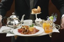 Butler serving English breakfast on tray — Stock Photo