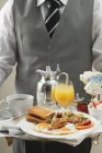 Butler serving breakfast — Stock Photo