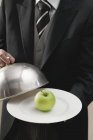 Maggiordomo che serve mela sul piatto — Foto stock