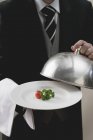 Butler servindo tomate e salsa na placa com tampa de cúpula, seção central — Fotografia de Stock