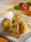 Apricot dumplings with buttered breadcrumbs on white plate — Stock Photo