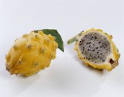 Pitahaya amarillo entero con la mitad - foto de stock
