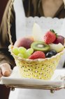 Waitress serving basket of fruit — Stock Photo