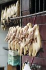 Daytime view of plucked poultry hanging at market — Stock Photo