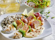 Fish and seafood kebabs with rice — Stock Photo