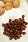 Closeup view of hazelnuts with flour and eggs — Stock Photo