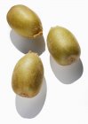 Three yellow kiwi fruits — Stock Photo