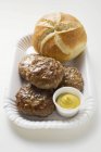 Beef burgers with mustard and bread roll — Stock Photo