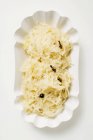 Sauerkraut in Papierschüssel von oben auf weißem Teller — Stockfoto