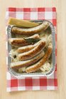 Sausages with sauerkraut in aluminium container — Stock Photo
