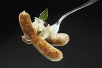 Sausages with sauerkraut on fork — Stock Photo
