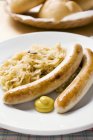 Sausages with sauerkraut and mustard — Stock Photo