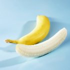 Plátanos sin pelar y pelados - foto de stock