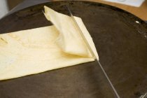 Vue rapprochée de la crêpe pliante sur la surface de friture — Photo de stock