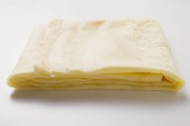 Vista de primer plano de crepé doblado en la superficie blanca - foto de stock