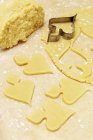 Vista close-up de biscoitos crus cortados com massa e cortador de biscoitos — Fotografia de Stock