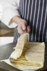 Cropped view of person folding crepe — Stock Photo