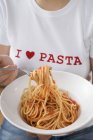 Woman eating spaghetti with tomato sauce — Stock Photo