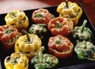 Stuffed peppers on black baking tray — Stock Photo