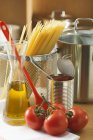 Massas secas de esparguete e tomates frescos — Fotografia de Stock