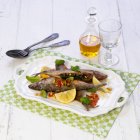 Sardines stuffed with spinach and pine nuts  on white plate  over towel — Stock Photo