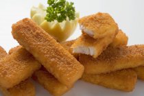 Dedos de pescado empanados con limón y perejil - foto de stock