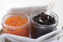 Caviar negro y caviar rojo en frascos - foto de stock