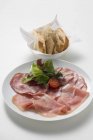 Raw ham and salami on plate — Stock Photo
