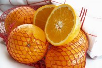 Апельсини у відкритій сітці — стокове фото
