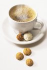 Steaming coffee cup with chocolates — Stock Photo