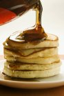 Pouring maple syrup over pancakes — Stock Photo