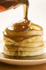 Pouring maple syrup over pancakes — Stock Photo