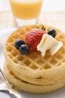 Waffles with butter and berries for breakfast — Stock Photo