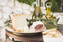 Queijo com salame e azeitonas na mesa — Fotografia de Stock