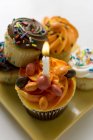 Асорті кекси, один зі свічкою на день народження — стокове фото