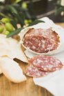 Salami and crackers on wooden table — Stock Photo