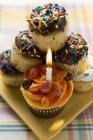 Muffins variados, um com vela de aniversário — Fotografia de Stock