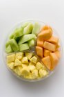 Pezzi di frutta fresca in ciotola di plastica — Foto stock