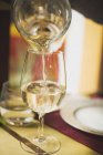 Despejando vinho branco da garrafa em vidro — Fotografia de Stock