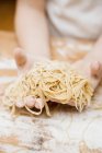 Child making homemade linguine pasta — Stock Photo